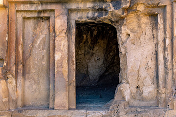 entrance to an ancient stone tomb carved into the rock