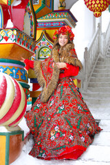 Beautiful long-haired blonde young girl in Russian traditional national clothes in winter the Izmailovsky Kremlin.