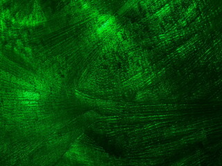 Frosty ice patterns on glass in green light.