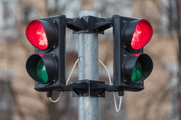 Red traffic light, city background. Semaphore showing a red light in both directions. Everything is...