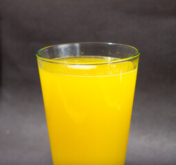 Glass of fresh orange juice with fruits cut in half and sliced isolated on gray background, clipping path