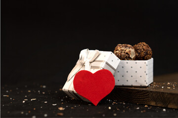 Chocolate truffle candies in a white gift box with a red heart. Sweet gift for valentine's day. Congratulations to your loved one.