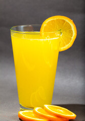 Glass of fresh orange juice with fruits cut in half and sliced isolated on gray background, clipping path