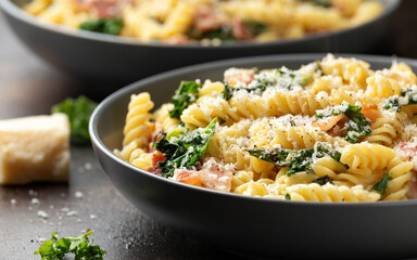 Fusilli pasta with bacon, kale and parmesan cheese. Healthy food