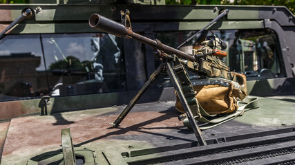 Machine gun Kalashnikov on the tripod and optical sight.M249 light machine gun with 7.62 mm cartridge belt.Military action in the world. - obrazy, fototapety, plakaty