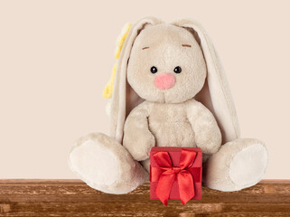 The toy rabbit sits on the table with a gift.