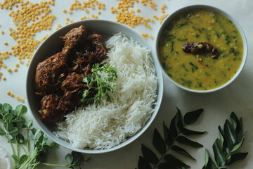 Kerala style dry chicken roast and lentil curry prepared with fenugreek leaves served with basmati...