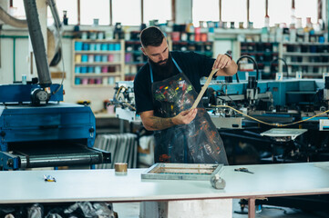 Male worker preparing screen printing film in a workshop