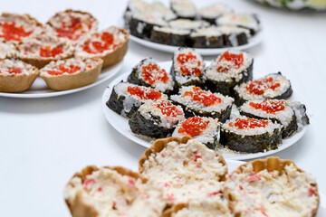 On the festive table are homemade sushi with red caviar, Japanese food.