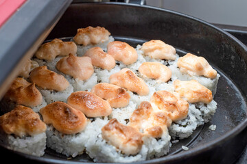 Homemade sushi is prepared on a baking sheet near the oven.