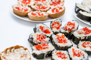 Homemade sushi covered with red caviar on a festive table, Japanese food, holidays.