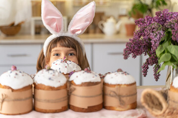 Fototapeta na wymiar Funny bunny child girl holds an Easter cake in his hands. Happy Easter. Homemade cakes for holidays, healthy food, healthy sweets for children