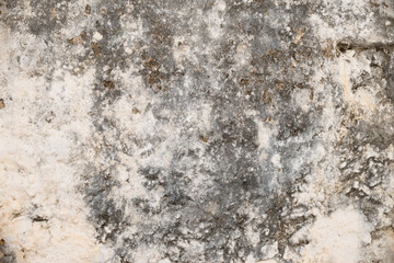Rough plastered wall with peeling off mortar and cracks