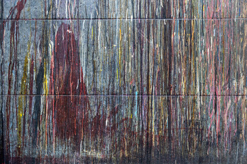 tiled wall with drops of paint of various colors accumulated over the years