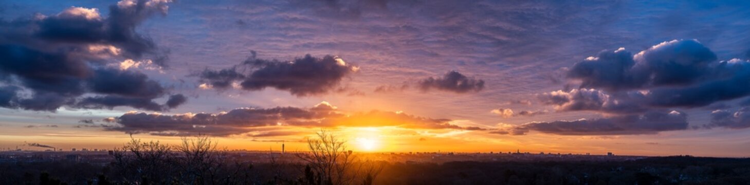 High resolution panorama image of sunrise with view over Haarlem and Amsterdam with orange and purple clouds 