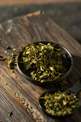 Fototapeta premium Fireweed or Ivan Chai, dried leaves, close-up. Healthy herbal fermented tea, natural antioxidant on rustic wooden textured table, dark mood photo with copy space. Organic herbal green tea.