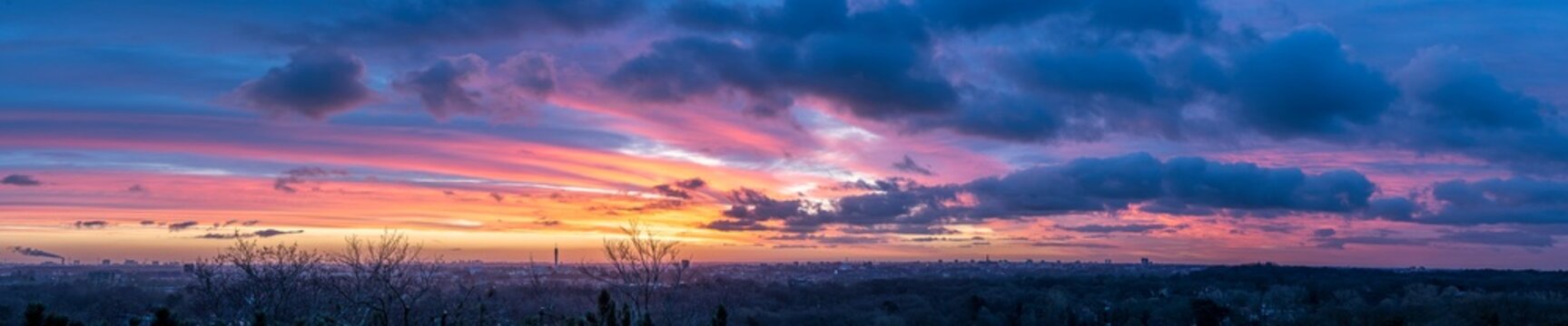 High resolution panorama image of sunrise with view over Haarlem and Amsterdam with orange and purple clouds 