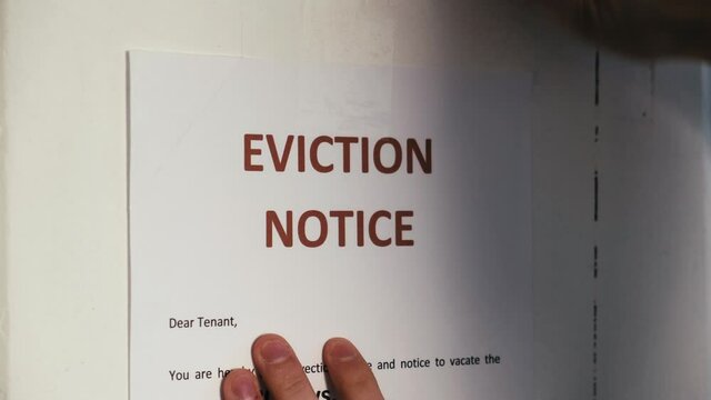 Male hands sticking paper sheet with inscription eviction notice