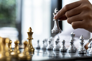 Person playing chess board game, business woman concept image holding chess pieces like business...