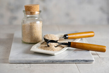 Psyllium husk on spoon soluble fiber supplement on white background. Superfood for healthy, lowers...