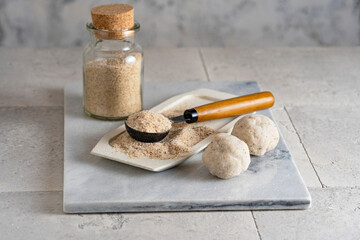 Psyllium husk on spoon soluble fiber supplement and raw bread or buns balls made of it before...