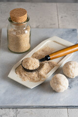 Psyllium husk on spoon soluble fiber supplement and raw bread or buns balls made of it before cooking. Superfood for healthy, lowers cholesterol, eases constipation. Keto, paleo low carb diet