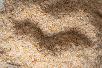 Psyllium husk close up background soluble fiber supplement on white background. Superfood for healthy, lowers cholesterol, balances blood sugar, boosts weight loss. Keto, paleo low carb diet
