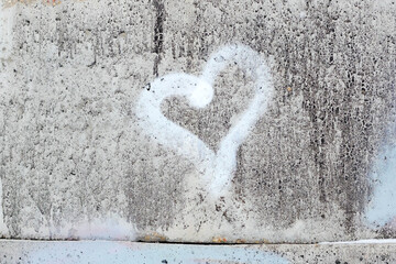 Heart on the concrete wall with white paint close-up. Confession of Love. Black with white texture concrete wall with  painted heart horizontally. Copy space