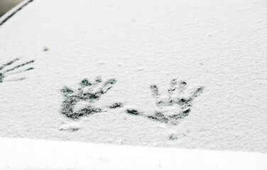 Winter, handprints on a snow windshield car