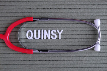 Quinsy - text from white letters on  green background with  stethoscope, medical concept diagnostics