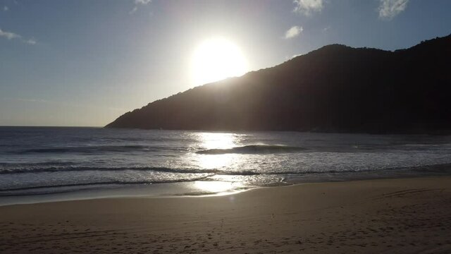 sunset at the beach with mountain in background
