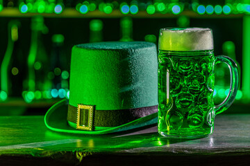 Mugs of green beer, ale on the bar counter. Holiday of Ireland on St. Patrick's Day in irish pub,...
