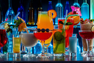 Set of coctails on bar counter in a restaurant, pub. Collection of fresh juice alcoholic drinks. Cooler beverage at nightclub on dark background