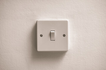 Light switch in on position on a white wall