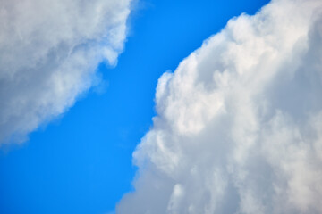 Bright landscape of white puffy cumulus clouds on blue clear sky