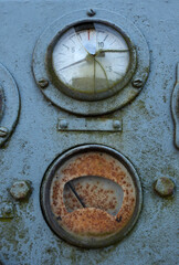Rusty and old metal dial indicators with broken glass on a machine