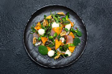Healthy salad with persimmon, microgreens, nuts and feta cheese. Fitness nutrition