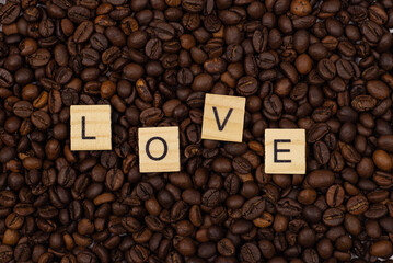 red heart and an inscription of letters on a background of coffee beans. Love coffee concept. St. Valentine's Day. View from above.