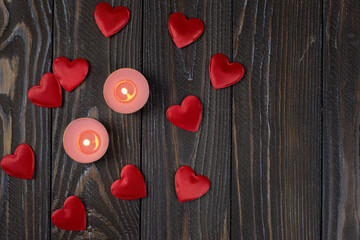 Romantic concept with candle and hearts on a wooden background. St. Valentine's Day