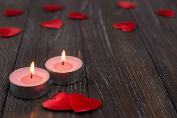 Romantic concept with candle and hearts on a wooden background. St. Valentine's Day