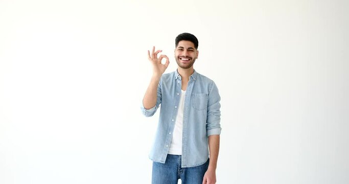 Young man showing ok gesture with hand over white background 