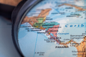 Costa Rica on a world map through magnifying glass. Costa Rica travel destination planning 