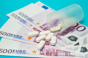 Money pills. Medicine pills on euro bills on a blue background. Covid-19 coronavirus pills are in euro money. The concept of insurance medicine, insurance, high cost, high cost of drugs.