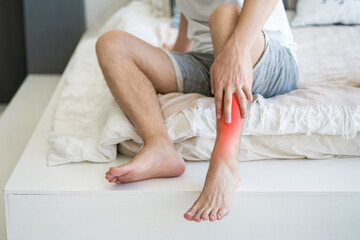 Fototapeta premium Shin pain, man suffering from ache and doing self-massage at home
