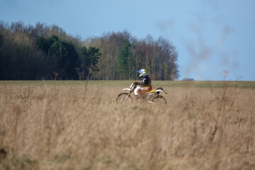 a motorcyclist (biker) riding their off-road Suzuki 250 motorbike along a stone track on Salisbury Plain, Wiltshire