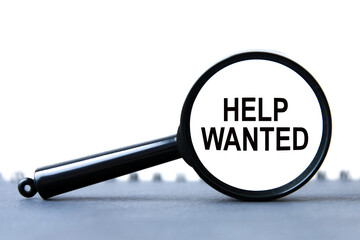 look closely and Help Wanted with a magnifying glass. business concept. magnifying glass on the gray background