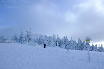 View from Brona Pass to Babia Gora Peak in winter misty day. Diablak, Beskid Zywiecki, Poland. Silhouette of people on pass.