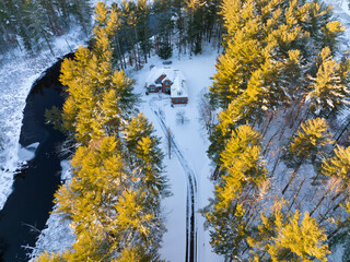 aerial view of house in woods after snow storm under sunlight