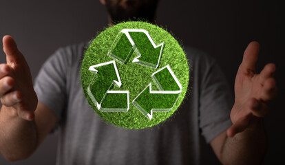 hand holding green recycle symbol