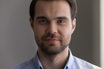 Head shot portrait close up of confident handsome young man face, skincare, serious bearded millennial guy posing for profile picture, successful businessman entrepreneur executive looking at camera